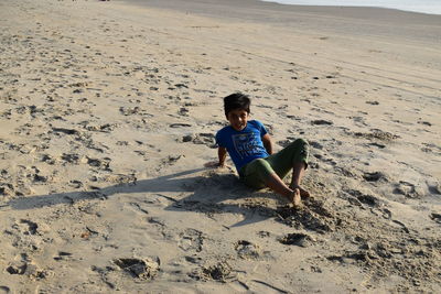 High angle view of boy sitting on beach