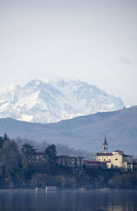 Scenic view of lake by snowcapped mountains against sky