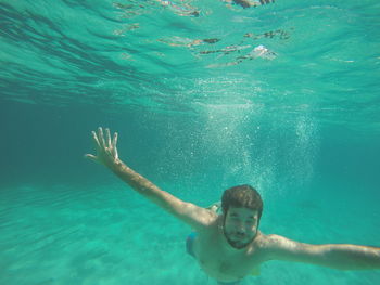 Shirtless man swimming undersea