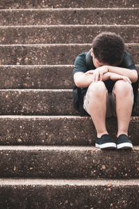 Full length of teenage girl sitting on staircase