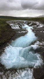 Scenic view of waterfall against sky