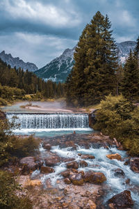 Scenic view of waterfall against sky