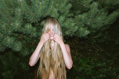 Smiling young woman with long hair in forest