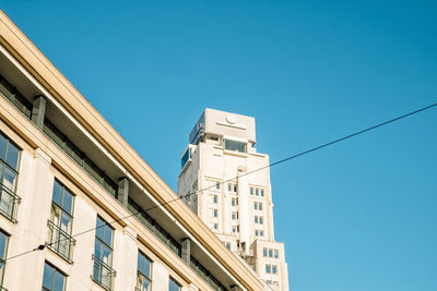 Low angle view of buildings against clear blue sky