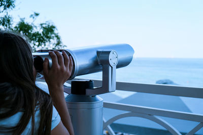 Woman looks through binoculars at the sea. traveler vacation holiday concept. new travel destination