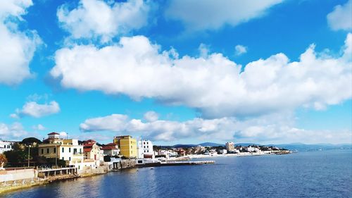 Scenic view of sea by buildings against sky