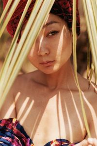 Close-up of young woman looking away amidst plant