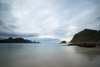 Scenic view of sea and mountains against sky