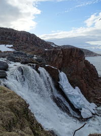 Scenic view of waterfall against sky during winter