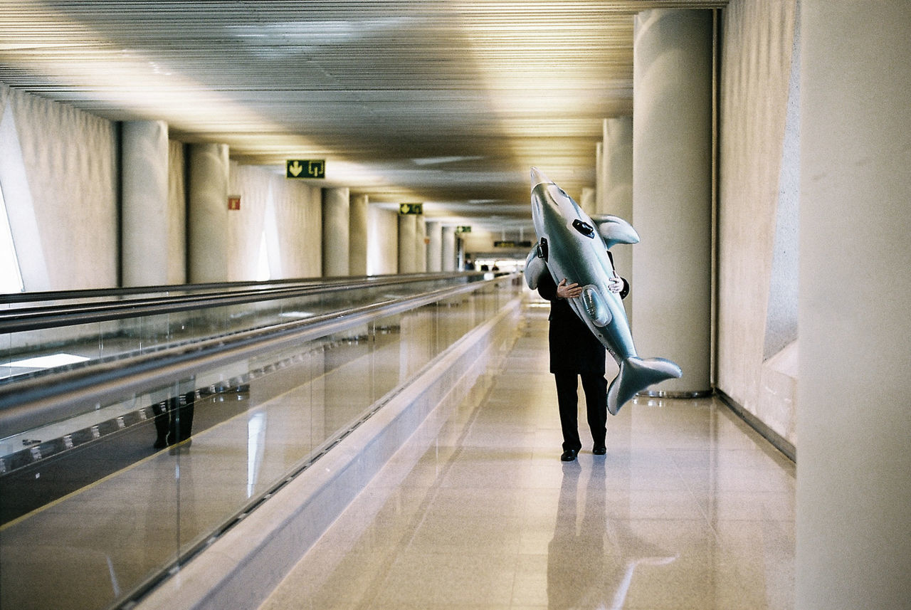 indoors, architecture, one person, public transport, adult, full length, metro station, walking, women, arcade, transport, transportation, corridor, travel, interior design, motion, subway, illuminated, lifestyles, on the move, built structure, luggage, building, person