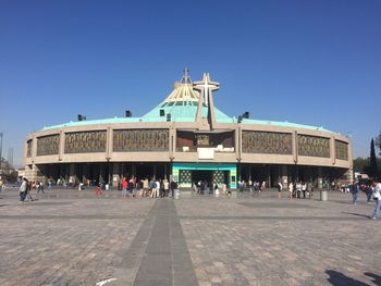 Tourists against clear blue sky