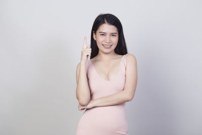 Portrait of a smiling young woman against white background