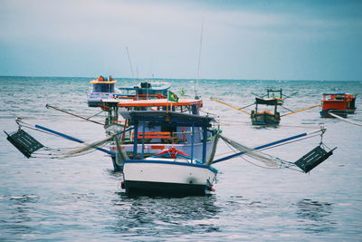 Fishing boat in sea against sky