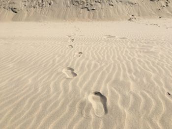 High angle view of footprints on sand at beach
