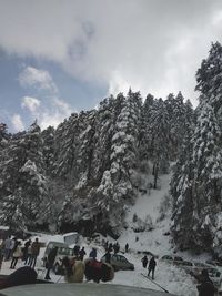 People on snow covered mountain against sky