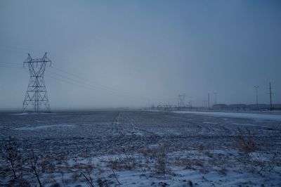 Electricity pylon on snowy field