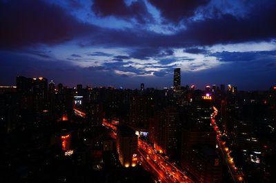 Illuminated cityscape against sky at night