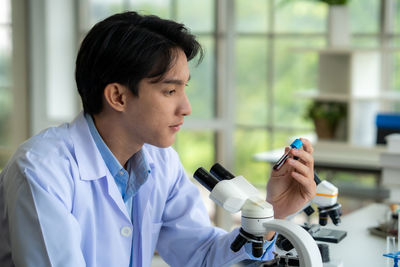 Side view of young woman drinking glass