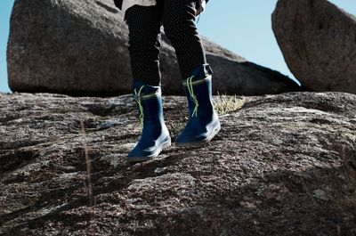 Low section of child boots standing on floor