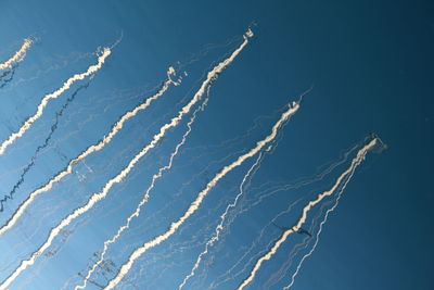 Low angle view of vapor trail against blue sky