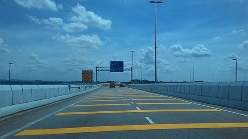 Empty road against cloudy sky