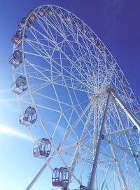 Low angle view of ferris wheel against blue sky