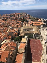 High angle view of townscape by sea against sky