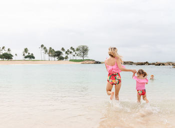 Mother and daugher playing in the ocean