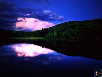 Scenic view of lake against sky at night