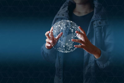 Digital composite image of man holding crystal ball