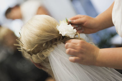 Bridesmaid adjusting hair of bride