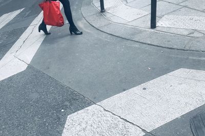 Low section of woman walking on footpath