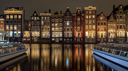 Medieval houses and cruise boats at the damrak in amsterdam the netherlands by night