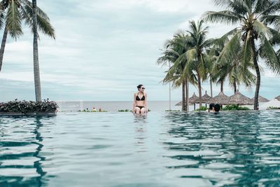 Man swimming in sea against sky