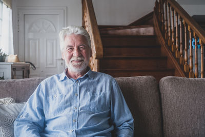 Portrait of smiling man sitting on sofa at home