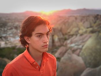 Close-up of thoughtful teenage boy looking away at sunset