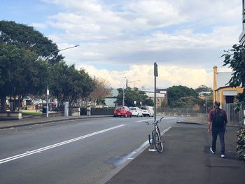 Rear view of people on street in city against sky