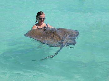 Woman swimming by stingray in sea