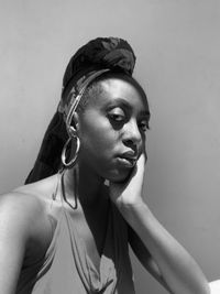 Young woman looking away against wall