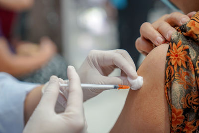 Cropped hands of doctor injecting syringe