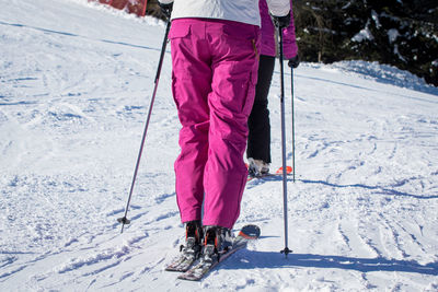 Low section of people skiing on snowy field