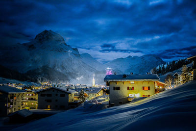 Buildings against mountain range at dusk during winter