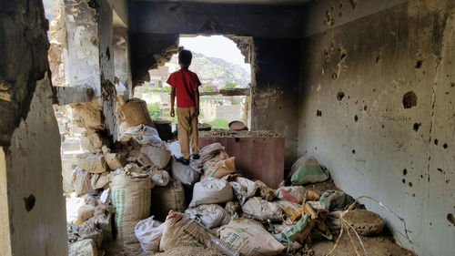 Rear view of man standing in abandoned building