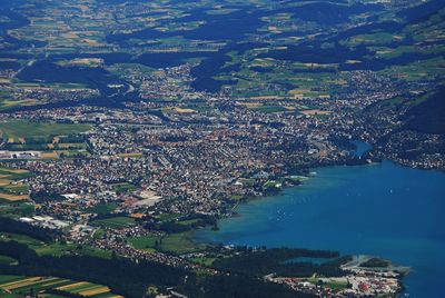 High angle view of illuminated city by sea