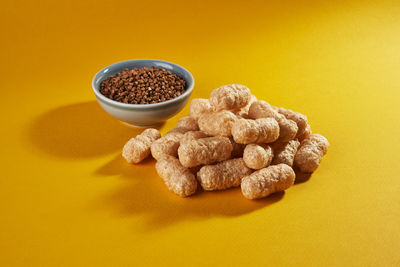 High angle view of roasted coffee beans on yellow background
