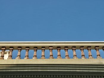 Low angle view of balustrade against clear blue sky