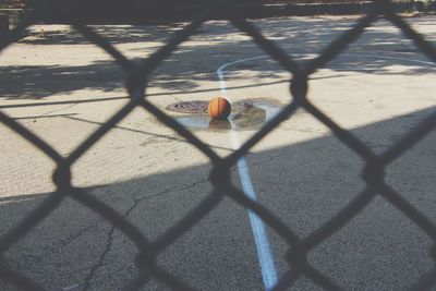 Basketball seen through chainlink fence