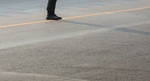 Low section of person standing on road