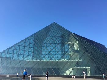 Low angle view of office building against blue sky