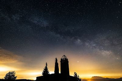 Low angle view of silhouette building against sky at night